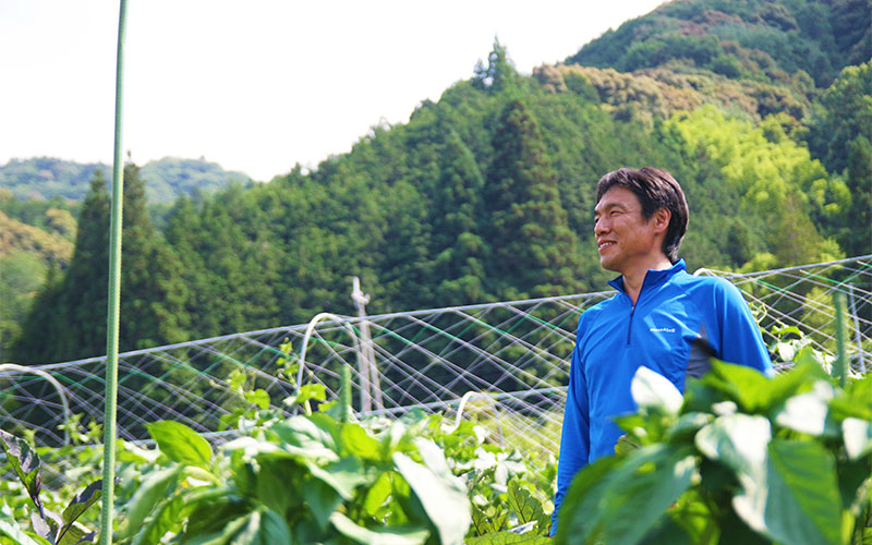 畑を見渡す宇城哲志さん