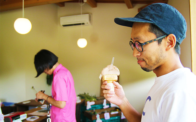 店内でジェラートを手にする林さんとお会計をする岩崎さん
