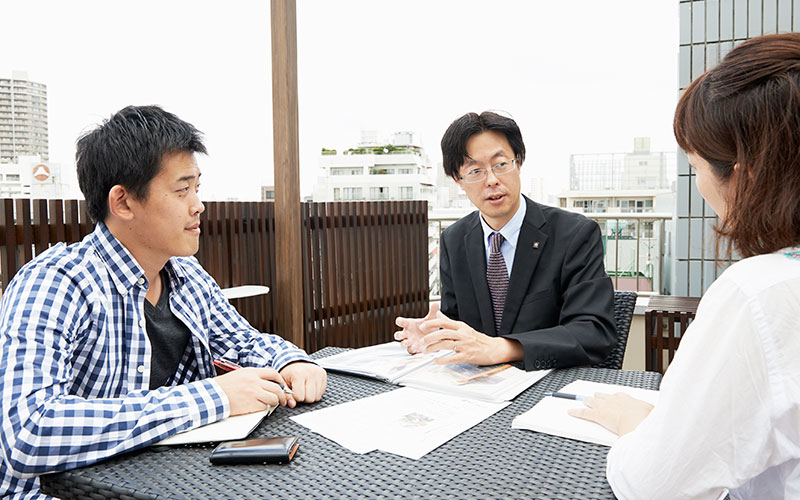 緑化の屋上テラスのテーブルで熊原さんの話を聞く取材班
