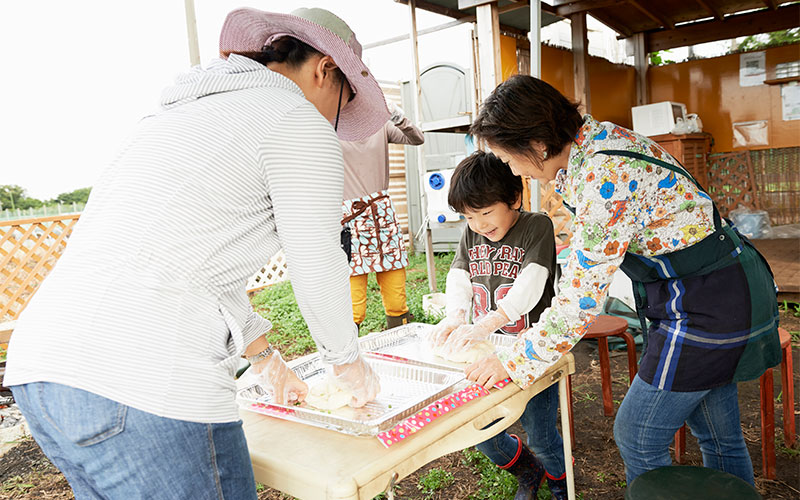 大人も子供も、みんなで協力して生地をこねています