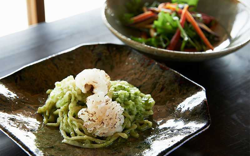 窓辺のテーブルのハモのパスタとサラダ。窓から見える景色と通る風でよりおいしく感じます