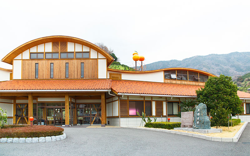みかん研究所の外観。みかん色の屋根の上にはみかんのオブジェ。