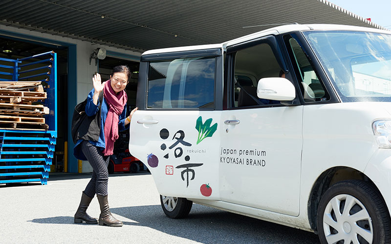 「洛市」のオリジナルラッピングカーに乗り込むふじわらさん