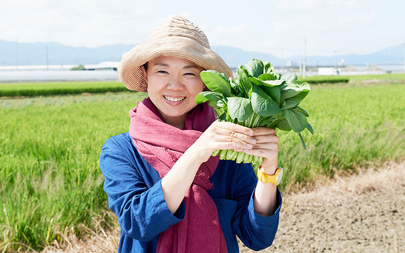 収穫したての小松菜を手に、ニッコリのふじわらさん