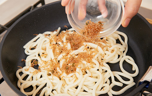 うどんにちりめん山椒を合わせる様子