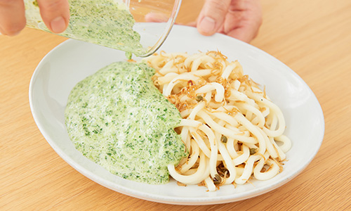 うどんにたっぷりソースをかける様子